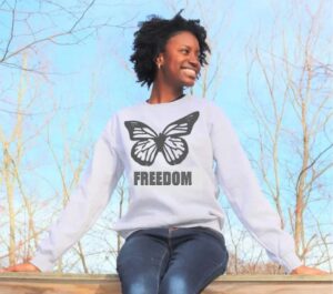 A woman wearing a white sweatshirt with a butterfly print