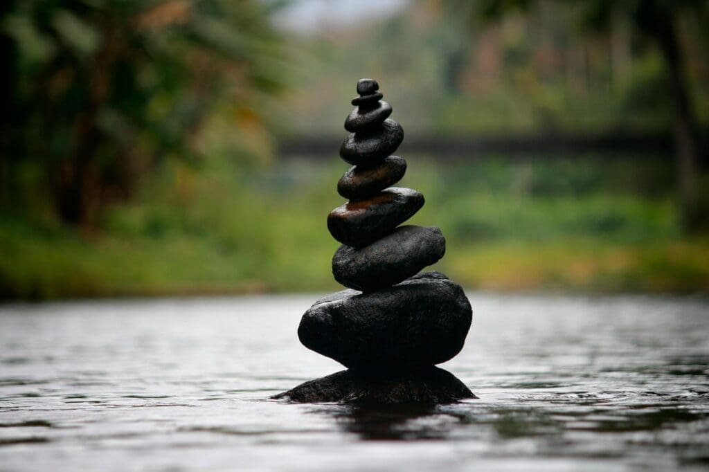 Stacked balancing stones in shallow river