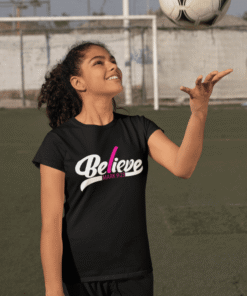Smiling girl tossing soccer ball on field