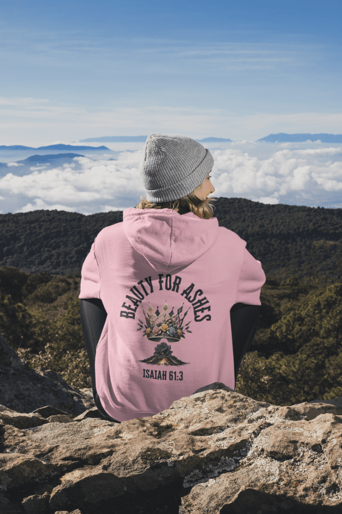 Person in pink hoodie overlooking mountainous cloudscape